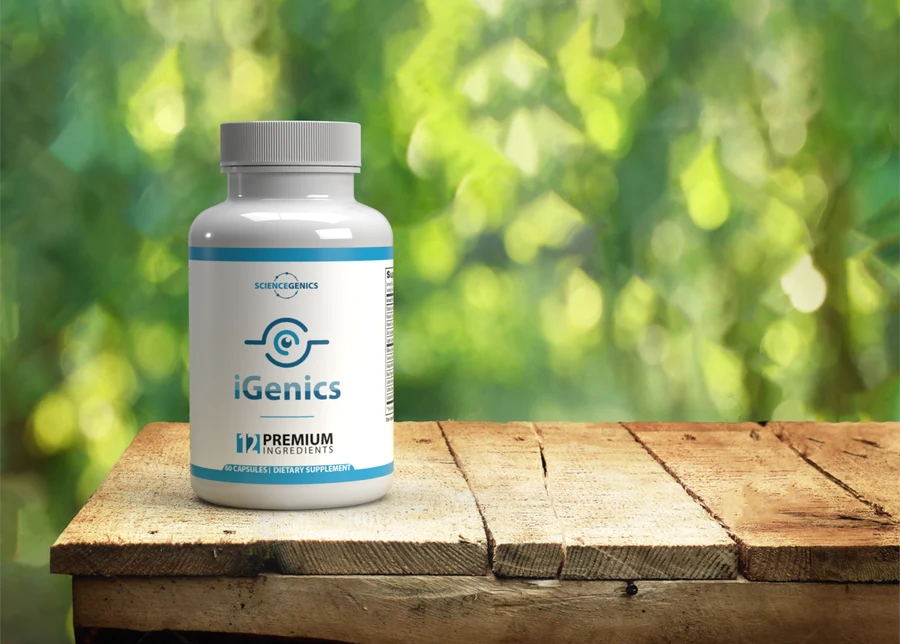 iGenics eye health supplement bottle on a wooden table with green foliage behind